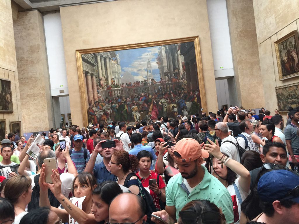 People observing the Mona Lisa painting