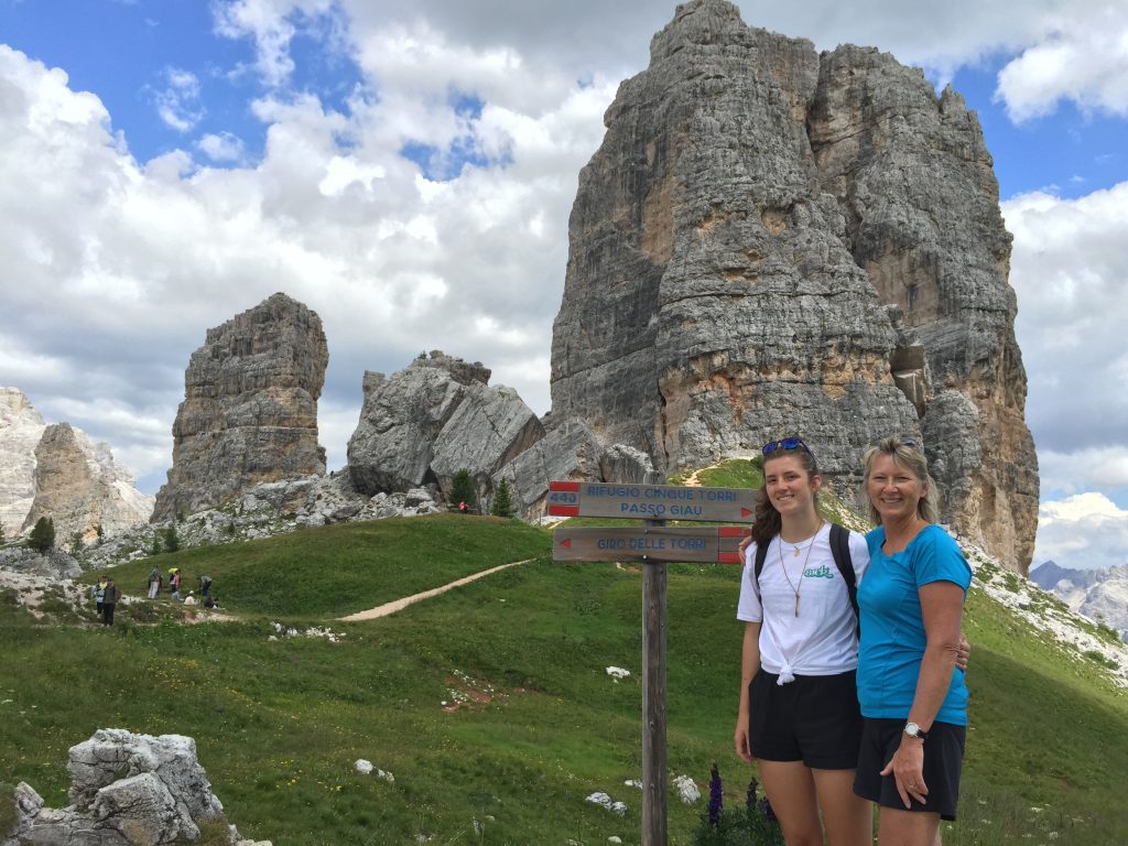 Mary and her daughter standing beside hiking trail signs in the Passo Giau area of the Dolomites