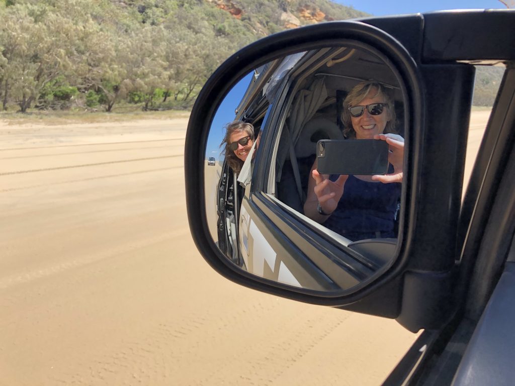 Driving along the beach road through Great White Sandy National Park, with expansive sandy landscapes