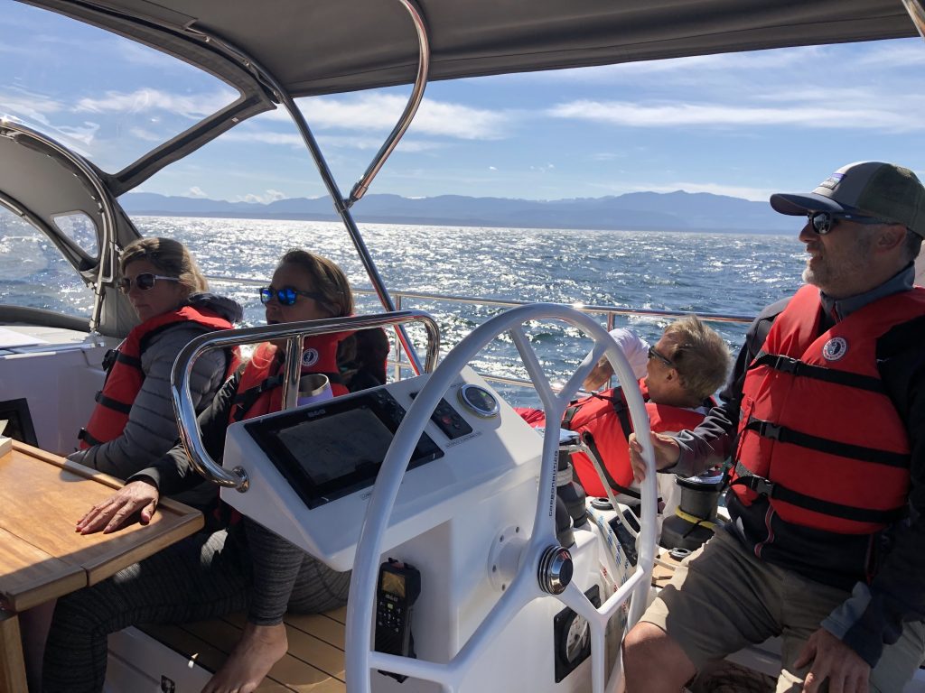 People sailing on a yacht wearing life jackets