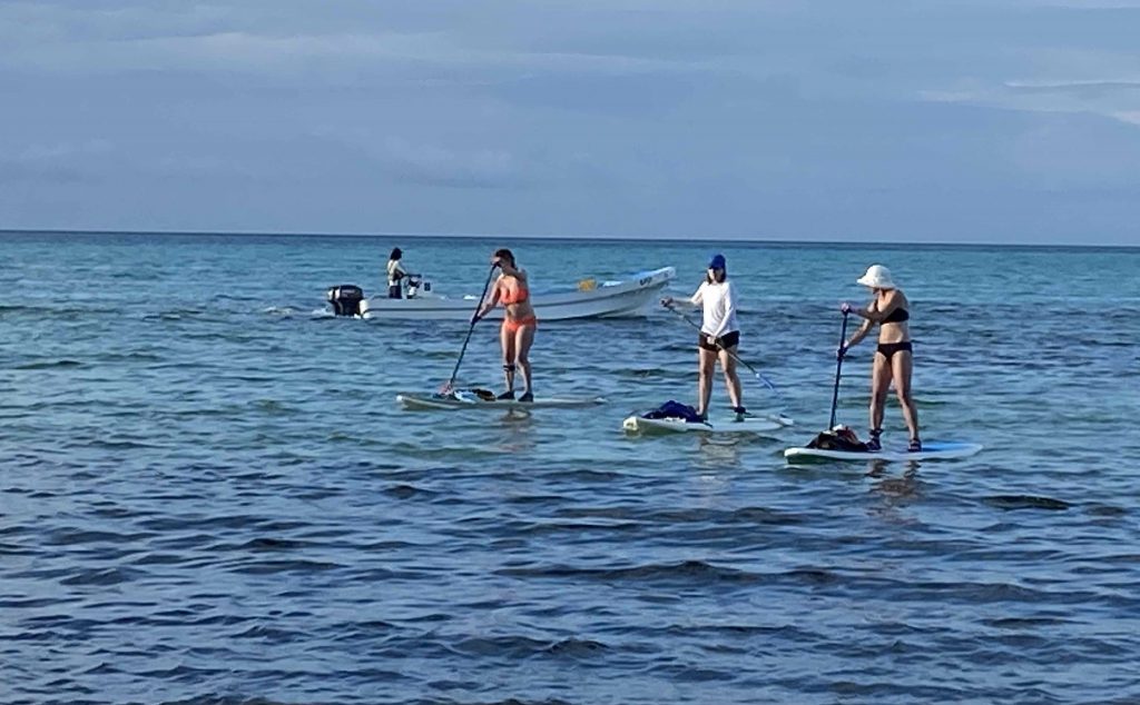 Girls paddleboarding during the Island Expeditions Belize kayaking adventure